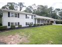 White brick home has a covered porch with black shutters and well-manicured yard at 3686 Calmer Cir, East Point, GA 30344