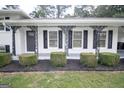 Inviting front porch with ironwork, black shutters, and manicured shrubs at 3686 Calmer Cir, East Point, GA 30344