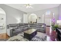 Open concept living room with a large sectional sofa, hardwood floors and decorative arched doorways at 1010 Capella Creek Way, Grayson, GA 30017