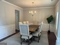 Elegant dining room with a chandelier, wainscoting, and a large wooden table with seating for six at 8109 Nolan Trl, Snellville, GA 30039