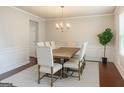 Bright dining room with elegant chandelier, wainscoting, and large table for gatherings at 8109 Nolan Trl, Snellville, GA 30039
