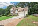 Two-story home featuring neutral siding, lush lawn, basketball hoop, and long driveway at 2580 Star Ln, Decatur, GA 30034