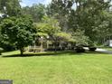 Inviting home with a covered front porch surrounded by mature trees and lush lawn at 807 Oak Bridge Ln, Fayetteville, GA 30214