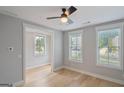 Cozy bedroom with hardwood floors, two windows, and a ceiling fan at 1100 Thomas St, Woodstock, GA 30188