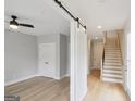 Bright entryway featuring hardwood floors, a sliding barn door, and stairs at 1100 Thomas St, Woodstock, GA 30188