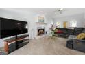 Bright living room featuring a fireplace, plush carpeting, and ample space for relaxation and entertainment at 150 Tramore Trce, Tyrone, GA 30290