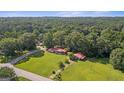 Sprawling property featuring a well-maintained home, carport, and lush landscaping, surrounded by dense woods at 6674 Cowan Mill Rd, Winston, GA 30187