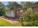Brick home with a chimney, updated siding, beautiful shrubs, and a newly renovated porch and walkway at 6674 Cowan Mill Rd, Winston, GA 30187
