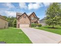 Inviting two-story home with an attached garage, lengthy driveway, and a lush green lawn at 2619 Dayview, Atlanta, GA 30331