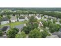 Wide aerial view of a residential neighborhood featuring mature trees and well-maintained homes with green lawns at 308 Sarasota Ln, Locust Grove, GA 30248