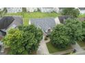 Aerial view of a two-story home featuring a gray roof, surrounded by mature trees in a residential neighborhood at 308 Sarasota Ln, Locust Grove, GA 30248
