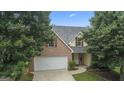 Charming two-story brick home featuring an attached two-car garage and a well-maintained front lawn and manicured landscaping at 308 Sarasota Ln, Locust Grove, GA 30248