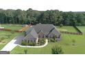 Beautifully landscaped home with lush green lawn, mature trees, and a long driveway at 116 Standford Dr, Mcdonough, GA 30252
