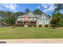 Stunning two-story home with stone accents, a inviting front porch, and a perfectly manicured lawn at 125 Seawright Dr, Fayetteville, GA 30215