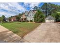 Beautiful home showcasing an exterior with lush greenery, an attached two-car garage, and a long concrete driveway at 125 Seawright Dr, Fayetteville, GA 30215