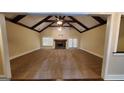 Large living room with vaulted ceiling, exposed beams, fireplace, and carpet floors at 90 Alcovy Reserve Way, Covington, GA 30014