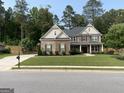 Attractive exterior view of the home showcasing its well-kept lawn and traditional architectural style at 6660 Canyon Cv, Cumming, GA 30028