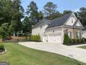 View of the driveway and garage, highlighting the home's ample parking and storage space at 6660 Canyon Cv, Cumming, GA 30028