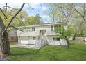 Charming split-level home with a gray exterior, landscaped lawn, and an attached garage at 474 Autumn Dr, Riverdale, GA 30274