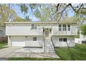 Charming split-level home with a gray exterior, landscaped lawn, and an attached garage at 474 Autumn Dr, Riverdale, GA 30274
