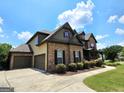 Lovely two-story brick home with a three-car garage and beautifully landscaped front yard at 206 Birchin Dr, Woodstock, GA 30188