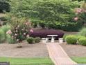 Serene garden area featuring a stone table with benches and colorful landscaping at 121 Pinnacle Ln, Mcdonough, GA 30253