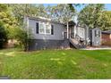 Charming single-Gathering home featuring gray siding and a well-maintained front lawn and landscape at 1675 Brewer Sw Blvd, Atlanta, GA 30310