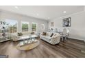 Bright and airy living room with modern furniture, wood floors, and ample natural light at 8717 Lakeview Commons, Jonesboro, GA 30238