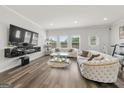 Stylish living room featuring plush seating, modern entertainment center, and large windows at 8717 Lakeview Commons, Jonesboro, GA 30238