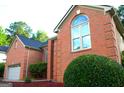 Lovely exterior elevation featuring brick facade, well manicured landscaping, and an attached garage at 122 Carolinas Way, Fayetteville, GA 30215