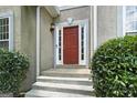 Close up of the front door with sidelights and beautiful landscaping at 136 Barrington Grange Dr, Sharpsburg, GA 30277