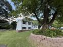 Backyard view showing a home with white siding, black shutters, and a beautifully terraced yard at 610 Tower Rd, Peachtree City, GA 30269