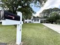 Well-manicured lawn leading to a two-story home with a convenient carport and a classic mailbox at 610 Tower Rd, Peachtree City, GA 30269