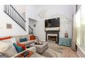 Bright living room with vaulted ceilings, a cozy fireplace, and a staircase leading to the upper level at 190 Country Club Dr, Hiram, GA 30141
