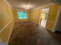 The well-lit dining room features classic wainscoting, plush carpeting, and an elegant chandelier at 1472 Queenie Smith Ne Rd, Conyers, GA 30012