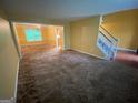 This airy living room offers comfortable carpeting, bright yellow walls, and a view to the dining area at 1472 Queenie Smith Ne Rd, Conyers, GA 30012