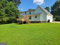 Spacious backyard featuring a wooden deck with stairs to the large lawn at 424 Ivey Edwards Ln, Mcdonough, GA 30253