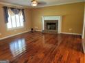 Bright living room features hardwood floors, a brick fireplace, and ample natural light at 424 Ivey Edwards Ln, Mcdonough, GA 30253