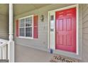 Inviting front porch with a vibrant red door, a window, and a welcoming doormat at 100 Walnut Ct, Stockbridge, GA 30281