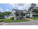 Well-maintained single-story home with a charming front porch, landscaped yard, and nearby neighborhood at 1 Hemlock, Porterdale, GA 30014