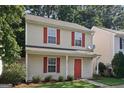 Well-maintained two-story home with red shutters and door, a manicured lawn, and mature trees at 162 Watercress Ct, Stockbridge, GA 30281