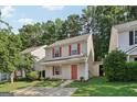 Inviting two-story home with a manicured lawn, red shutters and door, and a driveway at 162 Watercress Ct, Stockbridge, GA 30281