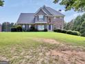 Attractive two-story home featuring a well-maintained lawn and traditional architectural details at 106 Big Cotton Trl, Mcdonough, GA 30252