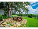 Outdoor dining area with a picnic table and stone patio, perfect for entertaining at 1074 Glenloch Rd, Roopville, GA 30170