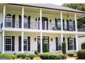 Elegant two-story home with a charming balcony and manicured landscaping at 1074 Glenloch Rd, Roopville, GA 30170
