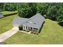 Aerial view of a home with a well-manicured lawn, driveway, and lush greenery surrounding the property at 120 Bramble Bush Trl, Covington, GA 30014