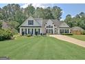 Inviting two-story home featuring a well-maintained lawn, attached garage, and attractive curb appeal at 155 Westminister Village Blvd, Sharpsburg, GA 30277