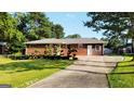 Traditional brick home with an extended driveway and professionally landscaped front yard at 1527 Patricia Dr, Morrow, GA 30260