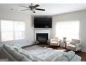 The living room offers a cozy fireplace, large windows, and comfortable seating, perfect for relaxation and entertaining guests at 11096 Cornerstone Way, Hampton, GA 30228