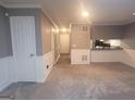 Open-concept living room with neutral carpet, white wainscoting and entry to the kitchen at 2052 Charter Ln, Lithonia, GA 30058